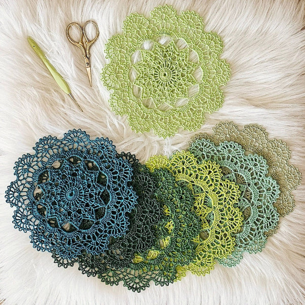 Set of seven round crochet coasters different shade of green each