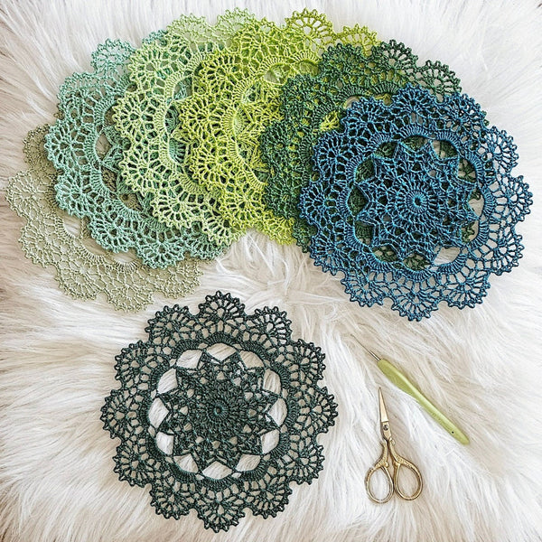 Set of seven round crochet coasters different shade of green each