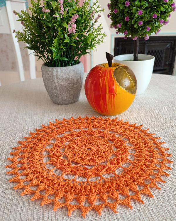 Bright and cheerful round orange crochet doily with a lot of textured 3D elements